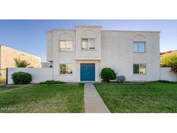 Charming two-story townhouse featuring a well-kept lawn and a bright blue front door at 5243 N 42Nd Ln, Phoenix, AZ 85019