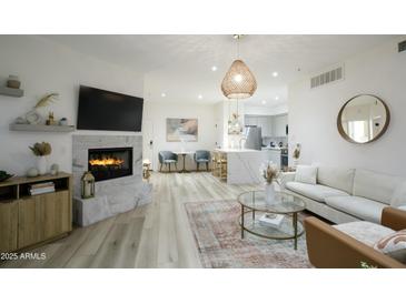 Bright living room with a fireplace, open floor plan, and modern decor at 1701 E Colter St # 488, Phoenix, AZ 85016
