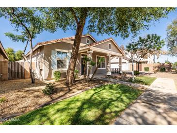 Charming single-story home with a well-manicured lawn and mature trees providing shade on a sunny day at 3756 E Waite Ln, Gilbert, AZ 85295