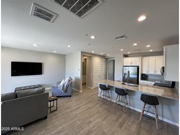 Spacious living room with modern furnishings, island seating, and neutral color palette at 4073 E Amoroso Dr, Gilbert, AZ 85296