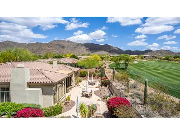Inviting backyard with lush landscaping, desert plants, comfortable seating areas, and a scenic golf course view at 42109 N Astoria Way, Anthem, AZ 85086