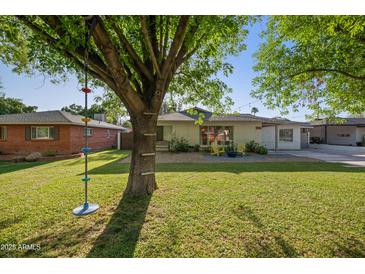 Charming home with a lush green lawn and mature tree, offering a welcoming curb appeal at 5812 N 18Th Pl, Phoenix, AZ 85016