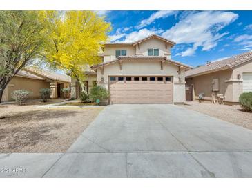 Two-story home with a large driveway and an attached two-car garage with a beige exterior at 6830 W Desert Ln, Laveen, AZ 85339