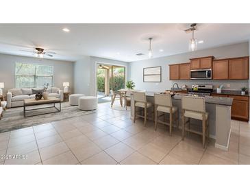 Open-concept living space with tile flooring connecting the kitchen, dining, and living areas at 18801 W Yucatan Dr, Surprise, AZ 85388
