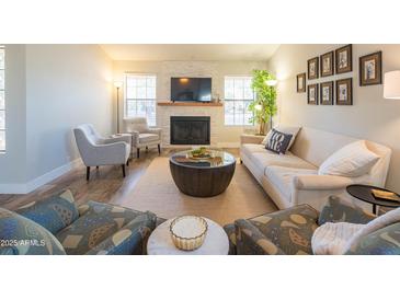 Bright living room featuring a cozy fireplace, modern furniture, and plenty of natural light at 11447 N 109Th St, Scottsdale, AZ 85259