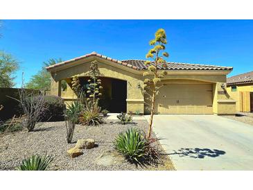 Charming home featuring a well-maintained yard with desert landscaping and a spacious two-car garage and tile roof at 18436 W Shasta St, Goodyear, AZ 85338