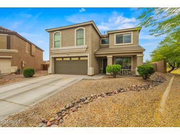 Two-story home with a neutral color scheme, a two-car garage, and low-maintenance desert landscaping at 21033 N Alexis Ave, Maricopa, AZ 85138