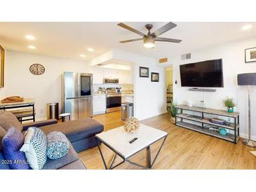 Bright living room with stainless steel appliances, sleek furniture, and an open floor plan at 3002 N 70Th St # 120, Scottsdale, AZ 85251