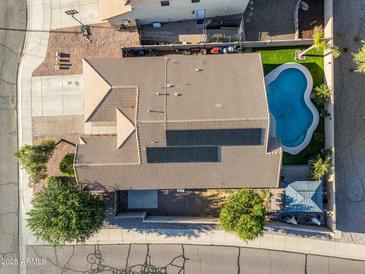 A high angle shows the house with a swimming pool, solar panels, landscaping and a tile roof at 32881 N Hidden Canyon Dr, San Tan Valley, AZ 85144