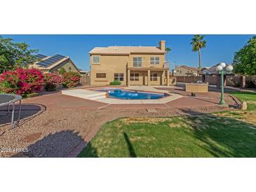 Expansive backyard featuring a pool, desert landscaping, outdoor kitchen and beautiful home at 2022 N 124Th Dr, Avondale, AZ 85392
