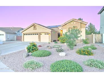 Inviting single-story home featuring a three-car garage, desert landscaping and solar panels at 329 S Marin Dr, Gilbert, AZ 85296