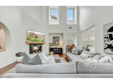 Bright living room with high ceilings, fireplace, large couch and clerestory windows providing natural light at 9433 E Trailside Vw, Scottsdale, AZ 85255