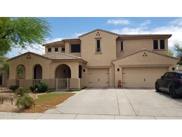 Charming two-story home featuring a spacious three car garage and arched porch at 15241 W Coolidge St, Goodyear, AZ 85395