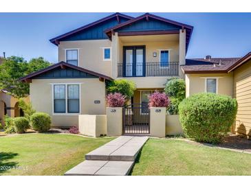 Inviting two-story home featuring lush landscaping, a gated courtyard, and a private second-story balcony at 15387 W Columbine Dr, Surprise, AZ 85379