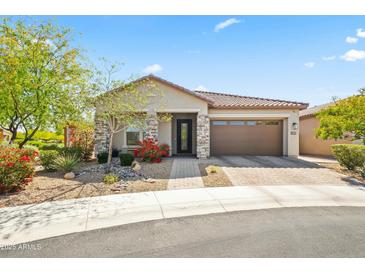 Charming single-story home featuring stone accents, a well-manicured yard, and a two-car garage in a residential neighborhood at 18129 N 65Th Pl, Phoenix, AZ 85054