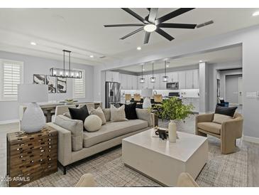 Inviting living room with plush seating, neutral tones, and an open layout connecting to the kitchen and dining area at 23046 E Camina Plata --, Queen Creek, AZ 85142