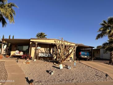 Charming home featuring a covered porch, desert landscaping, and a carport for convenient parking at 2511 N 56Th St, Mesa, AZ 85215