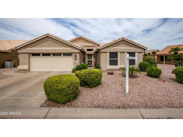 Charming single-story home featuring a two-car garage, well-manicured landscaping, and a neutral color palette at 3022 N 148Th Ave, Goodyear, AZ 85395