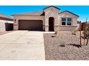 Single-story home with desert landscaping, a gray garage door, and a covered front entryway at 11946 E Cliffrose Ln, Florence, AZ 85132
