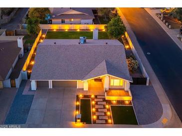 Beautifully landscaped home exterior with manicured lawn, lighted walkway, and a two-car garage at 2178 E La Jolla Dr, Tempe, AZ 85282