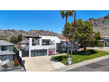Modern two-story home with a metal roof, 3-car garage, palm trees and a mountain backdrop at 2308 E State Ave, Phoenix, AZ 85020