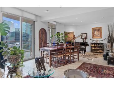 Bright living area with large windows, a dining table, and a piano, perfect for entertaining at 2402 E Esplanade Ln # 604, Phoenix, AZ 85016
