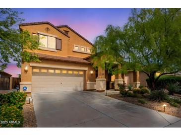 Charming home with a large driveway, a two-car garage, and desert landscaping at 2930 E Quiet Hollow Ln, Phoenix, AZ 85024