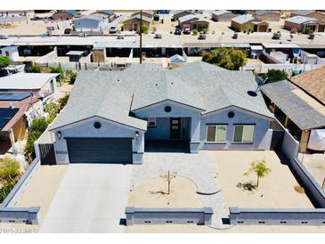 Charming light blue home with a large driveway and landscaped front yard, showcasing neighborhood views at 32101 W Palo Verde St, Wittmann, AZ 85361