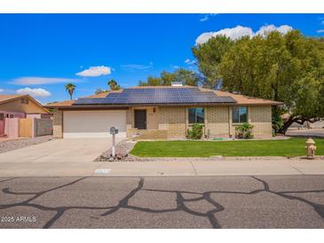 Charming single-Gathering home with solar panels, green lawn, and a two-car garage at 3556 E Angela Dr, Phoenix, AZ 85032