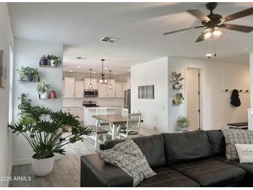 Inviting living room flows into a modern kitchen with white cabinetry and stainless steel appliances at 5549 S Dillon --, Mesa, AZ 85212