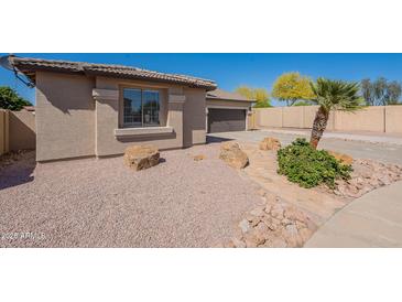 A single-story home featuring desert landscaping with a mix of rock and native plants enhancing its curb appeal at 7516 W Mary Jane Ln, Peoria, AZ 85382
