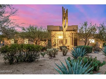 Desert home at sunset featuring lush desert landscaping, mature trees, and a grand entrance at 9627 E Adobe Dr, Scottsdale, AZ 85255
