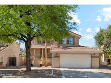 Charming two-story home featuring a well-maintained front yard, covered entryway, and attached two-car garage at 991 W Leah Ln, Gilbert, AZ 85233