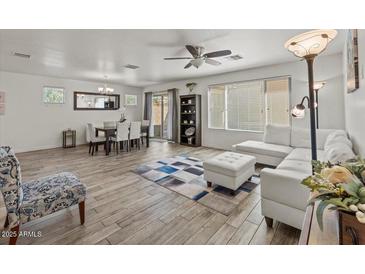 Open-concept living room with wood-look flooring, neutral decor, and ample natural light at 1317 N Balboa --, Mesa, AZ 85205
