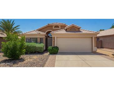 Charming single-story home with a well-maintained front yard, desert landscaping, and a two-car garage at 13421 W Ocotillo Ln, Surprise, AZ 85374