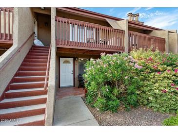 Charming two-story home featuring a cozy porch, stairs, and vibrant landscaping at 14203 N 19Th Ave # 1031, Phoenix, AZ 85023