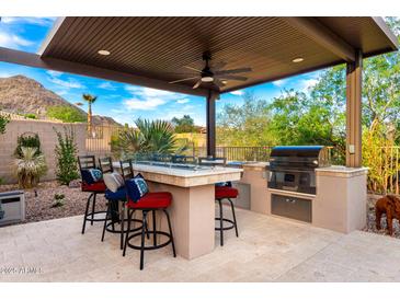 Outdoor kitchen and bar area with mountain views and seating at 16201 S 29Th Ave, Phoenix, AZ 85045