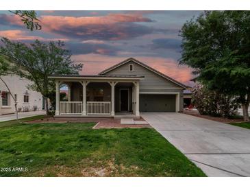 Beautiful single-story home showcasing a delightful front porch under a colorful dusk sky at 20866 W Hamilton St, Buckeye, AZ 85396