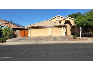 Charming home featuring a three-car garage, desert landscaping, and a tile roof at 2434 S Colleen --, Mesa, AZ 85210