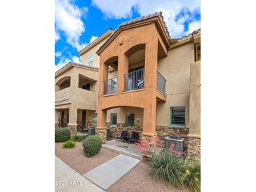 Beautiful two-story home with a charming balcony, stone accents, and desert landscaping at 2821 S Skyline Dr # 156, Mesa, AZ 85212