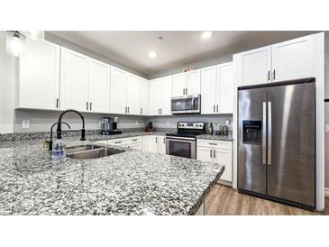 Beautiful kitchen with white cabinets, stainless steel appliances, and a large granite countertop island at 2821 S Skyline Dr # 156, Mesa, AZ 85212
