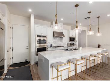 Bright modern kitchen with white cabinetry, quartz countertops, and stainless steel appliances at 7343 E Casitas Del Rio Dr, Scottsdale, AZ 85255