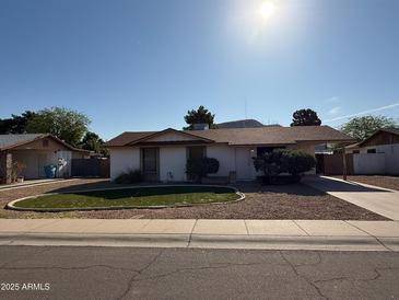 Charming single-story home with a well-manicured front yard and a covered carport at 12231 N 22Nd Ave, Phoenix, AZ 85029