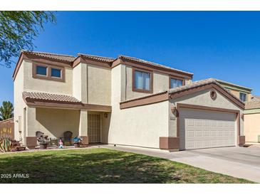 Charming two-story home featuring a well-maintained lawn and two-car garage at 12430 W Scotts Dr, El Mirage, AZ 85335