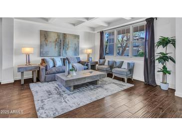 Bright living room featuring modern decor, plush seating, and an abundance of natural light through a large window at 16322 N 171St Dr, Surprise, AZ 85388