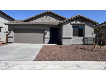 Charming single-story home featuring a neutral-toned exterior, a two-car garage, and low maintenance desert landscaping at 17488 W Fulton St, Goodyear, AZ 85338