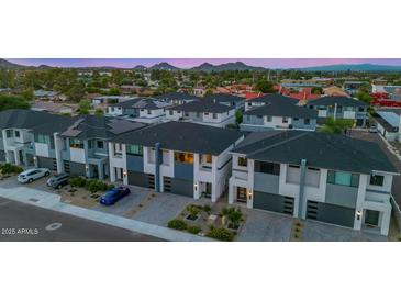 Modern townhomes featuring a two-story design and individual garages are complemented by well-maintained landscaping at 3136 E Cheryl Dr, Phoenix, AZ 85028