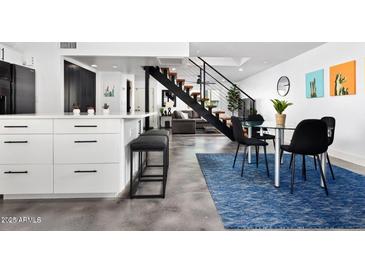 Open concept dining area with modern table, sleek chairs, and a view of the staircase at 4208 N Parkway Ave, Scottsdale, AZ 85251