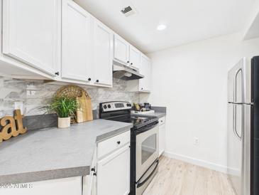 Well-lit kitchen with white cabinetry and stainless steel appliances at 7101 W Beardsley Rd # 621, Glendale, AZ 85308