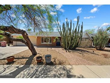Charming brick home with mature desert landscaping and a brick walkway at 8725 E Coronado Rd, Scottsdale, AZ 85257